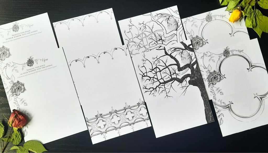 Set of gothic themed black ink illustrations printed on white pages, laying on a dark background with two dried roses in the corners.